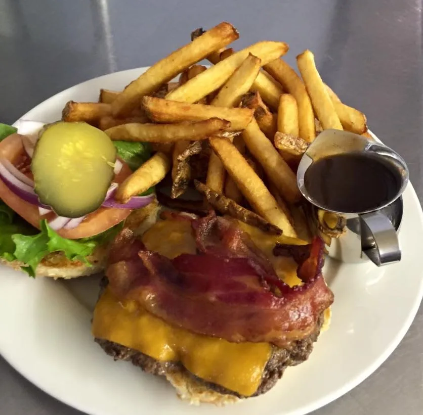 A bacon cheeseburger with fries and gravy