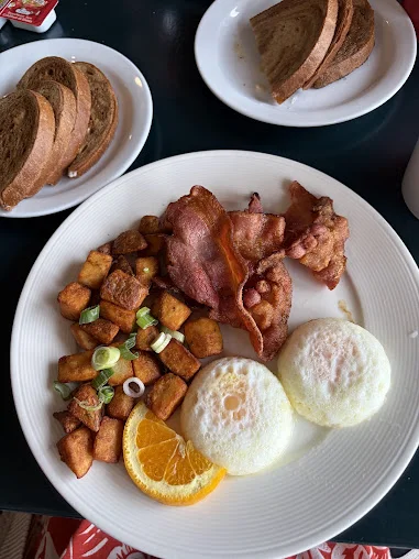 Two eggs with bacon, home fries, orange and rye toast