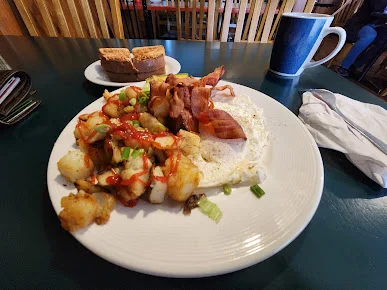 Home fries topped with bacon and eggs